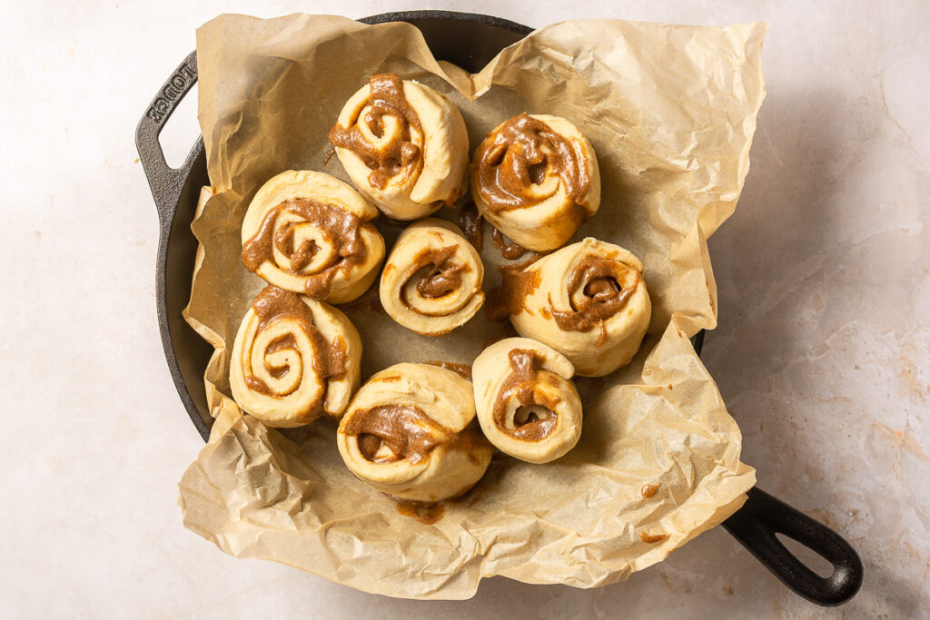 banana cinnamon roll dough in a parchment-lined pan