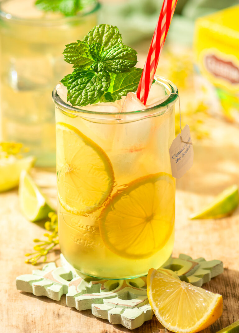 chamomile iced tea in a glass with lemon slices and mint garnish