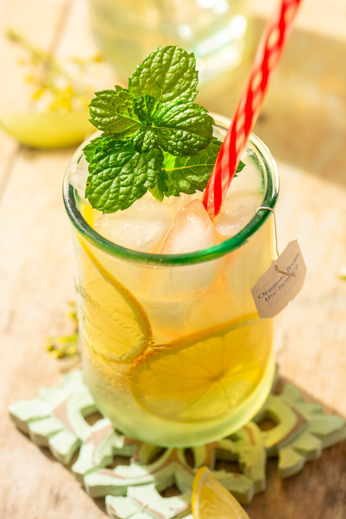 chamomile iced tea in a glass with lemon slices and mint garnish