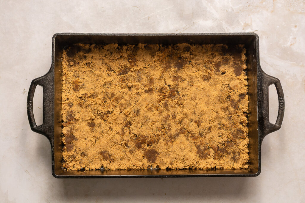 brown sugar pressed into cast iron baking pan for pineapple upside-down cake