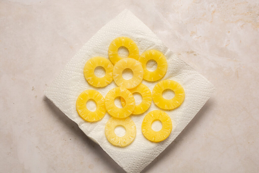 pineapple slices on a plate lined with paper towels
