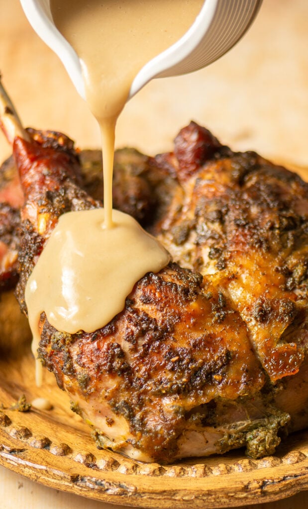 pouring turkey gravy on jerk turkey legs