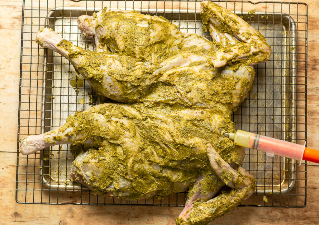 turkey covered in jerk compound butter and being injected with more jerk butter