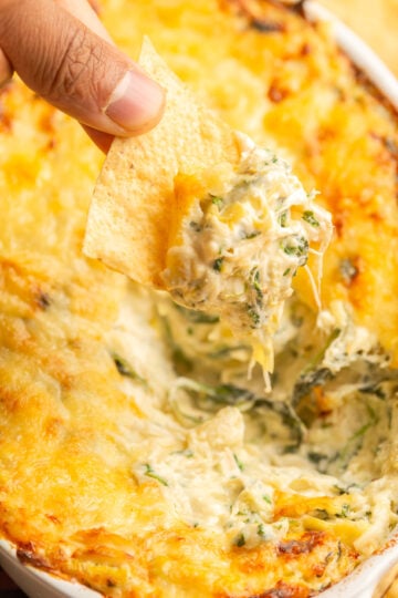 hot crab spinach dip scooped up with a tortilla chip