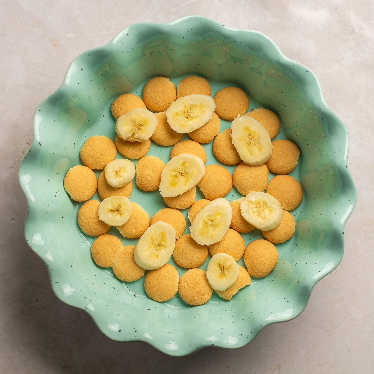 pie dish with a layer of Nilla wafers and sliced bananas.