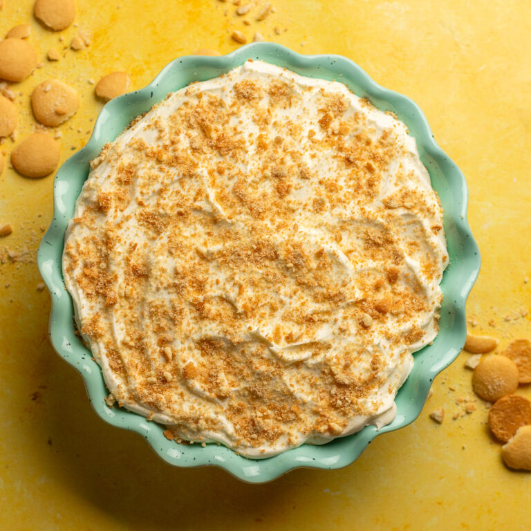 banana pudding from scratch topped with homemade whipped cream in a bowl.