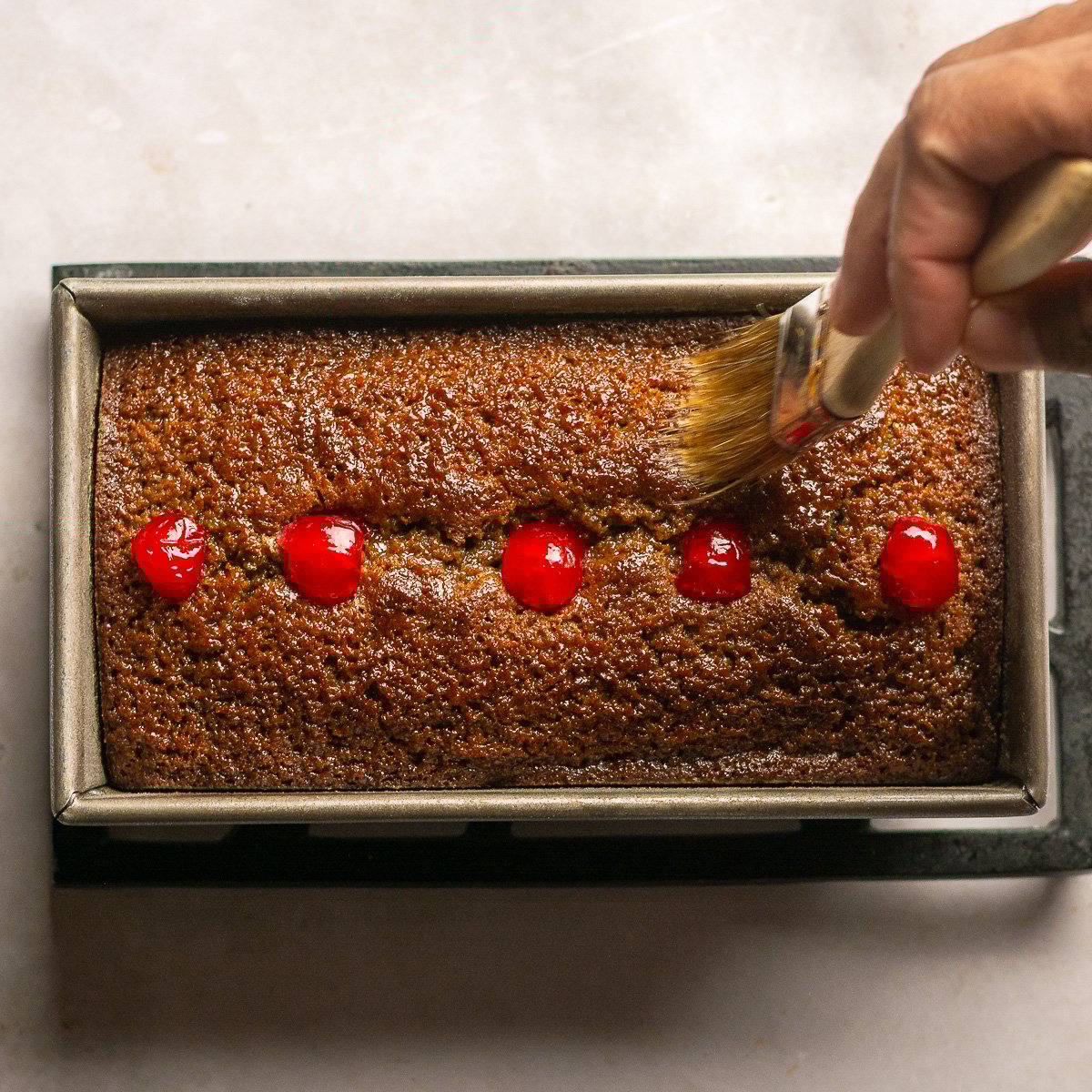 brushing baked Jamaican easter bun with Dragon stout glaze.