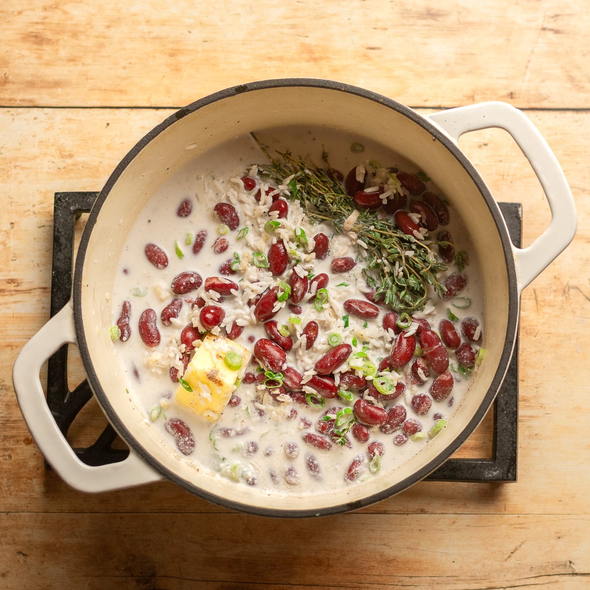 all ingredients for Quick Jamaican Rice and Peas with Canned Beans in a dutch oven.