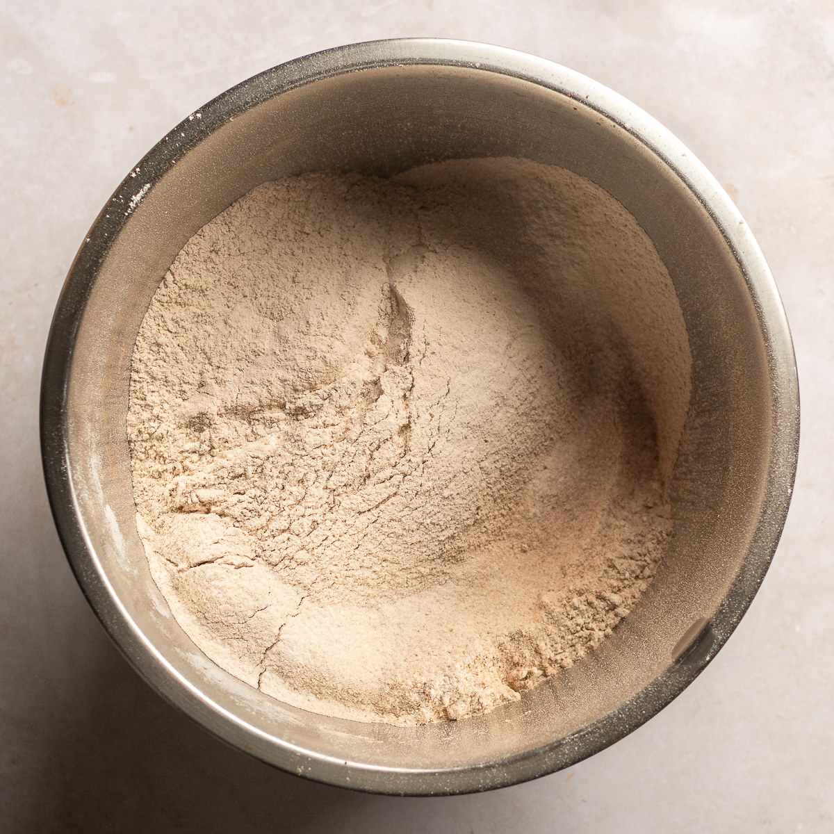 sifted dry ingredients for red velvet cake in a stainless steel bowl.