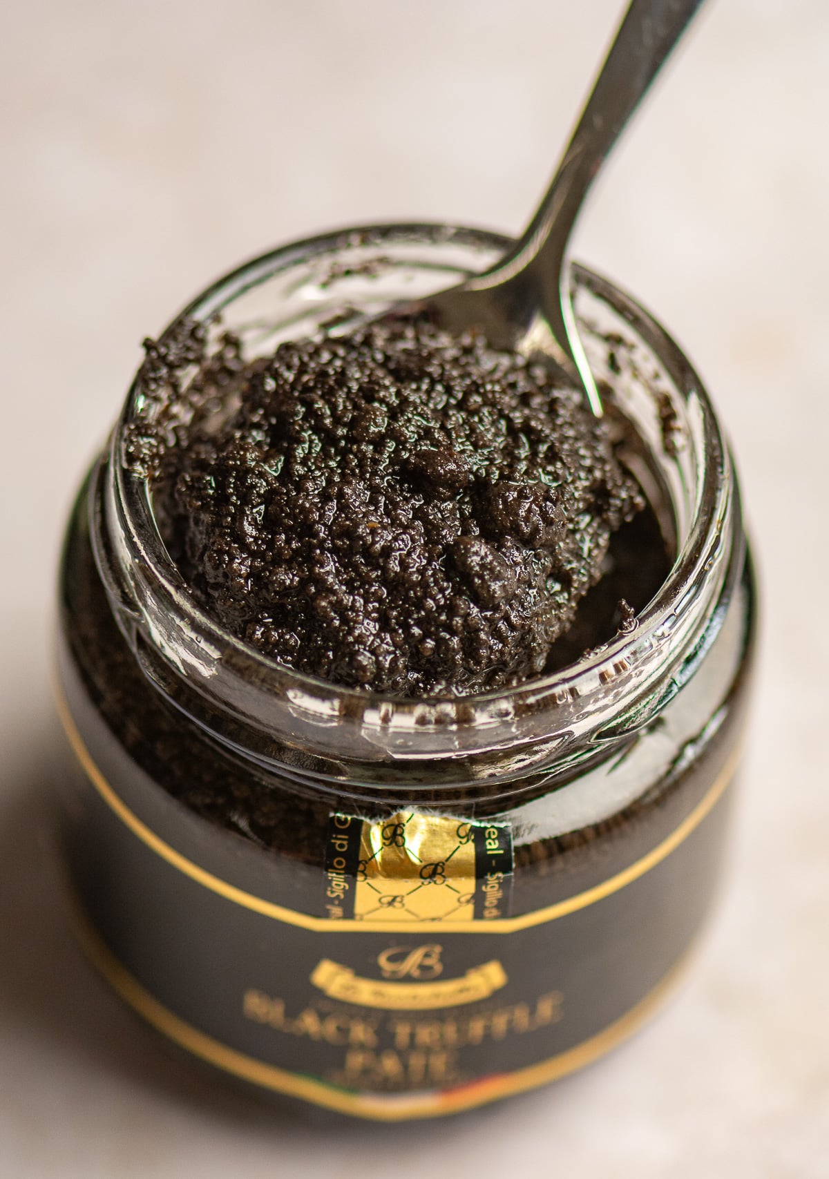 scooping truffle paté out of a jar with a spoon.
