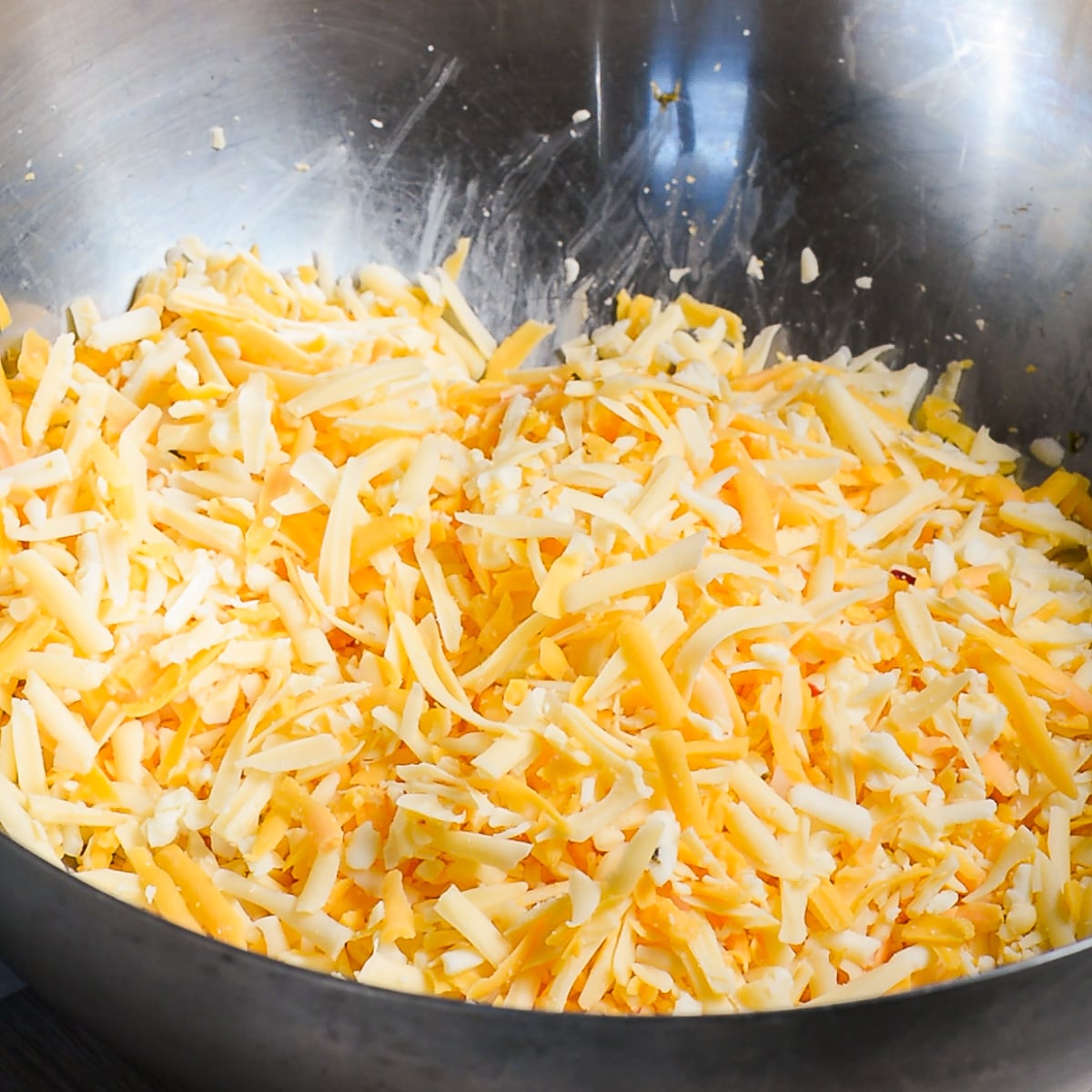 grated Gouda, pepper jack and sharp cheddar cheese in a bowl.
