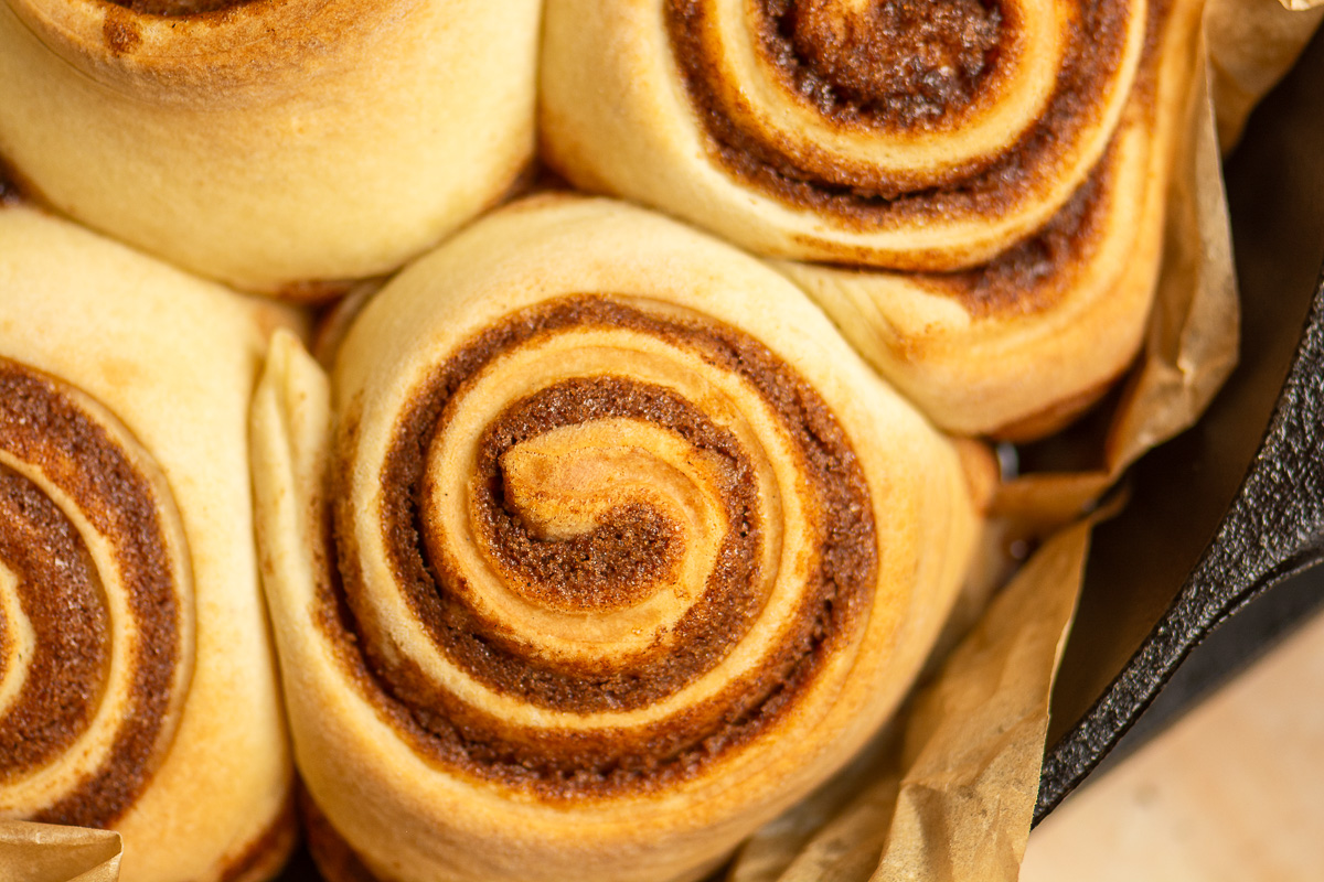 brioche cinnamon buns in a cast iron skillet.