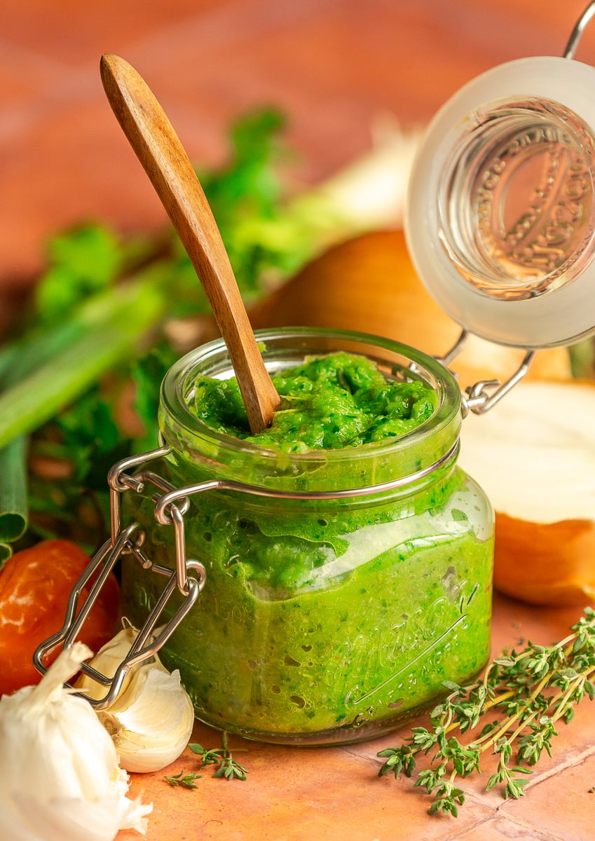 Jamaican green seasoning in a mason jar with a wooden spoon.