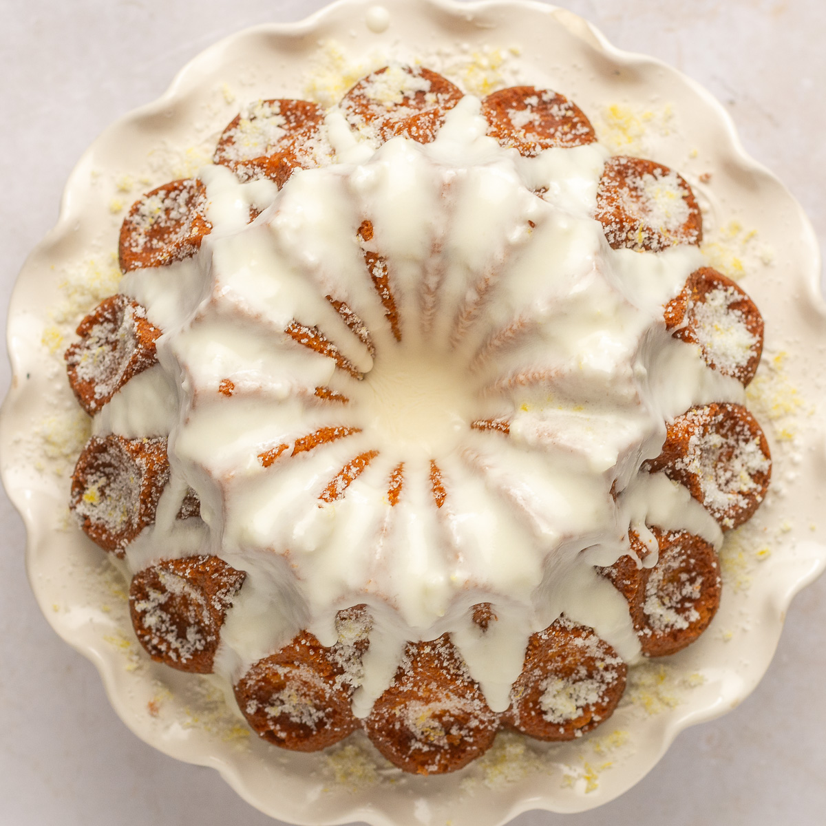 lemon yogurt bundt cake with lemon glaze on a cake stand.