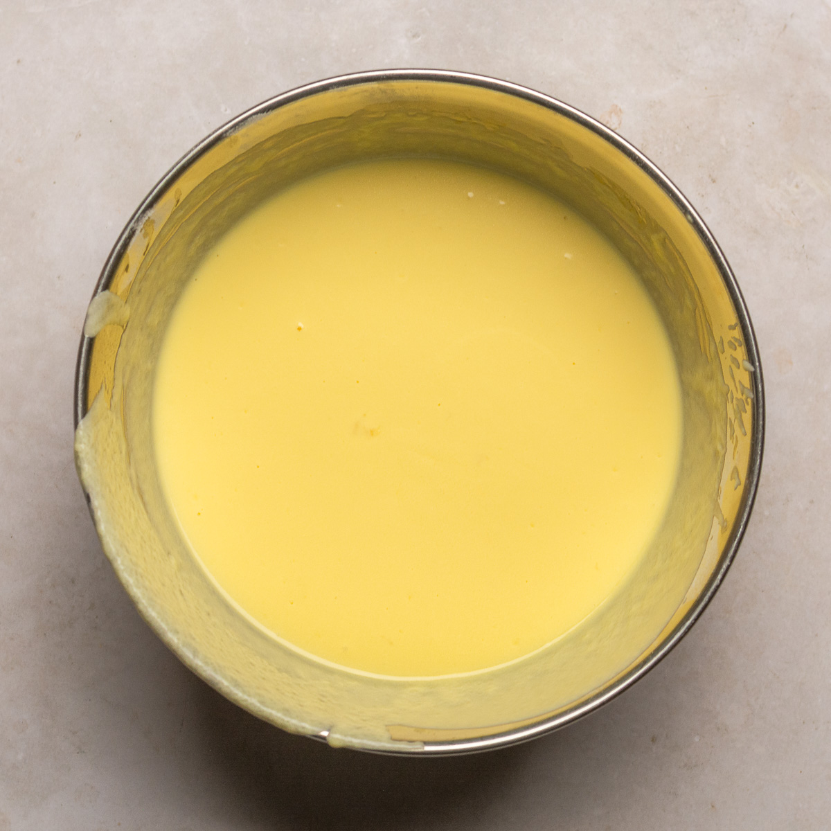 eggs and lemon yogurt whisked together in a stainless steel bowl.