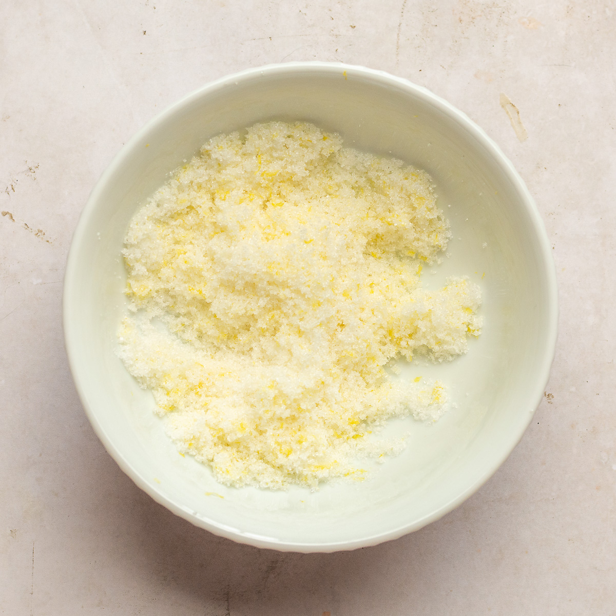 lemon zest rubbed into granulated sugar in a bowl.