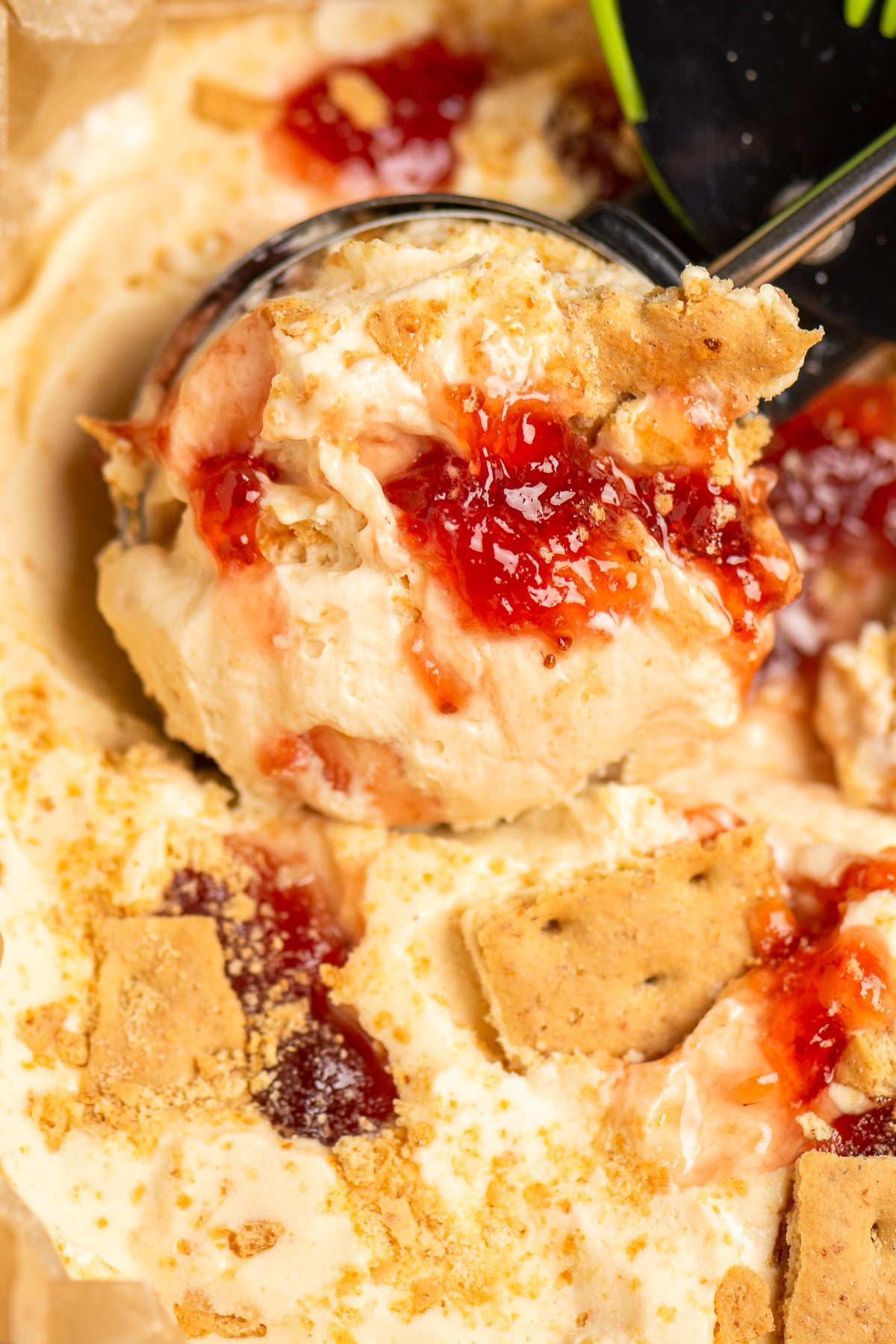 strawberry cheesecake ice cream being scooped with ice cream scoop.