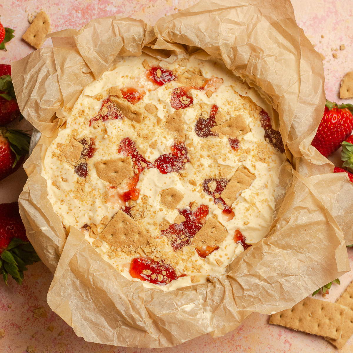 layering strawberry cheesecake ice cream with strawberry preserves and graham crackers.