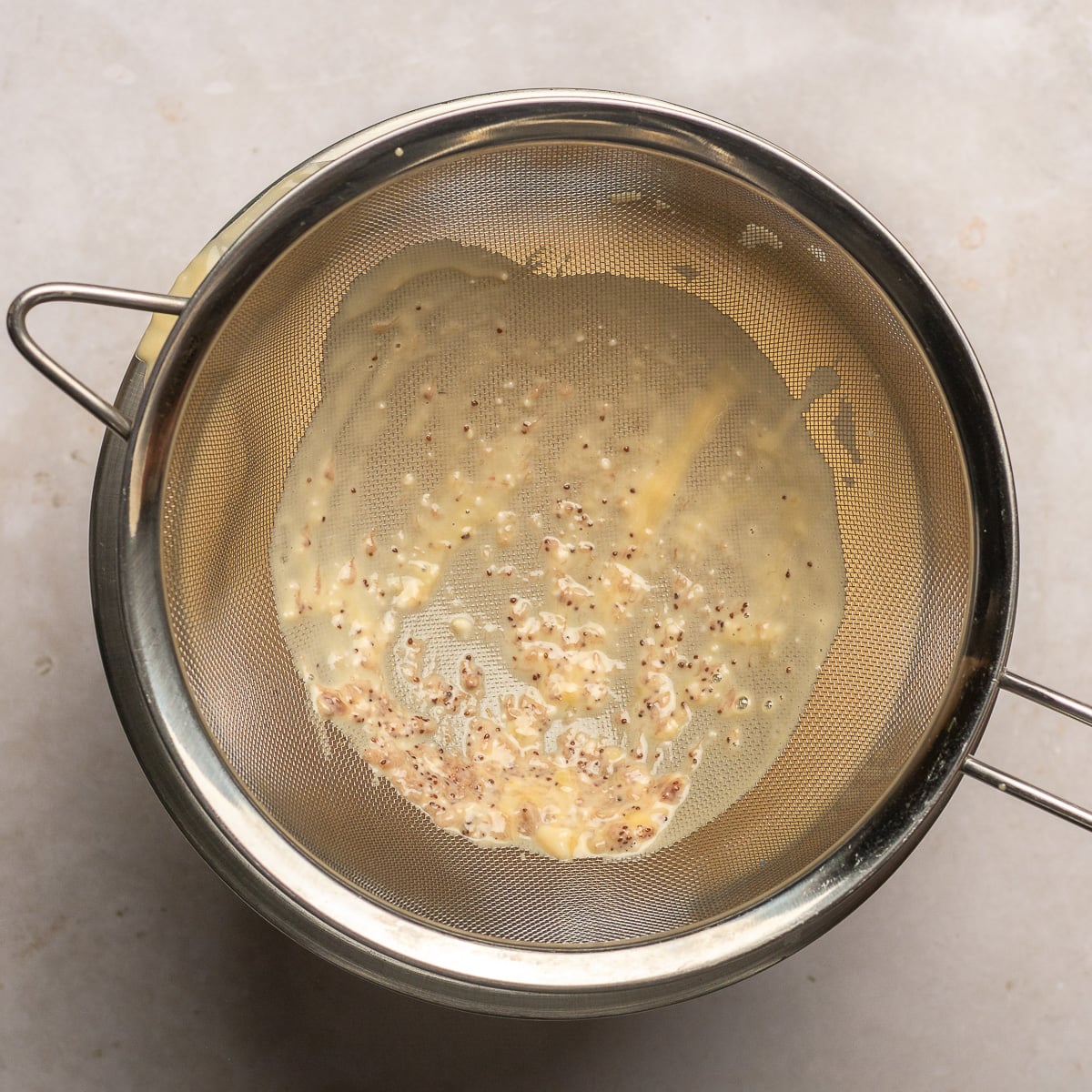 straining strawberry cheesecake ice cream custard.