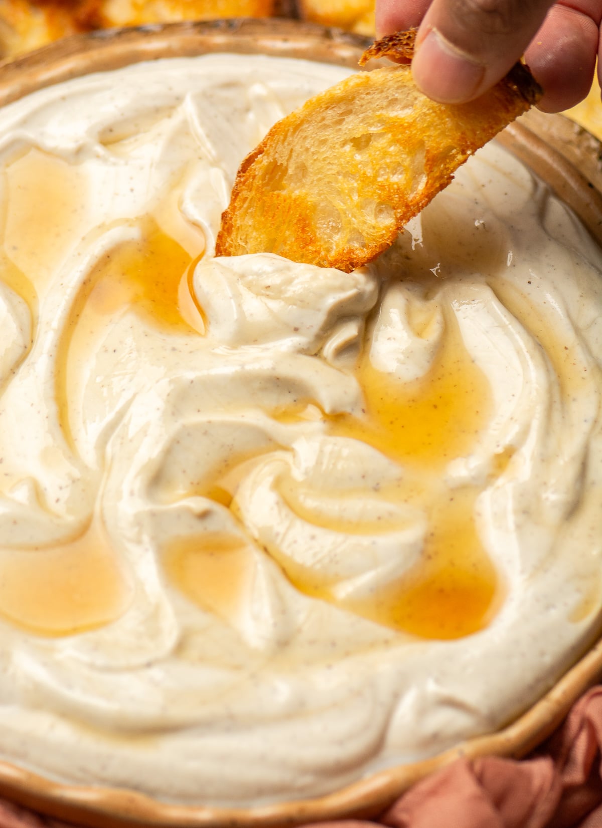 scooping up whipped ricotta with truffle and honey with a crostini.