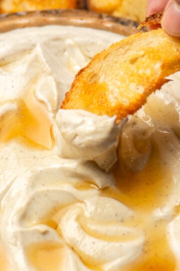 scooping up whipped ricotta with truffle and honey with a crostini.