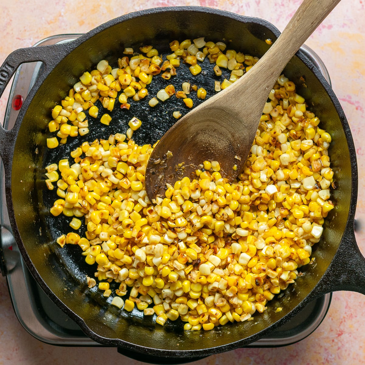 cooking corn kernels in a cast iron pan.