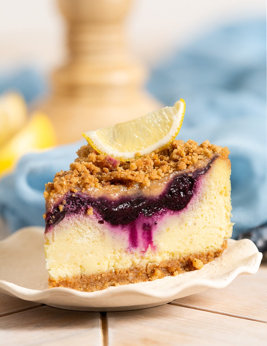 slice of blueberry lemon crumble cheesecake on a plate.
