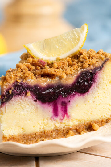 slice of blueberry lemon crumble cheesecake on a plate.
