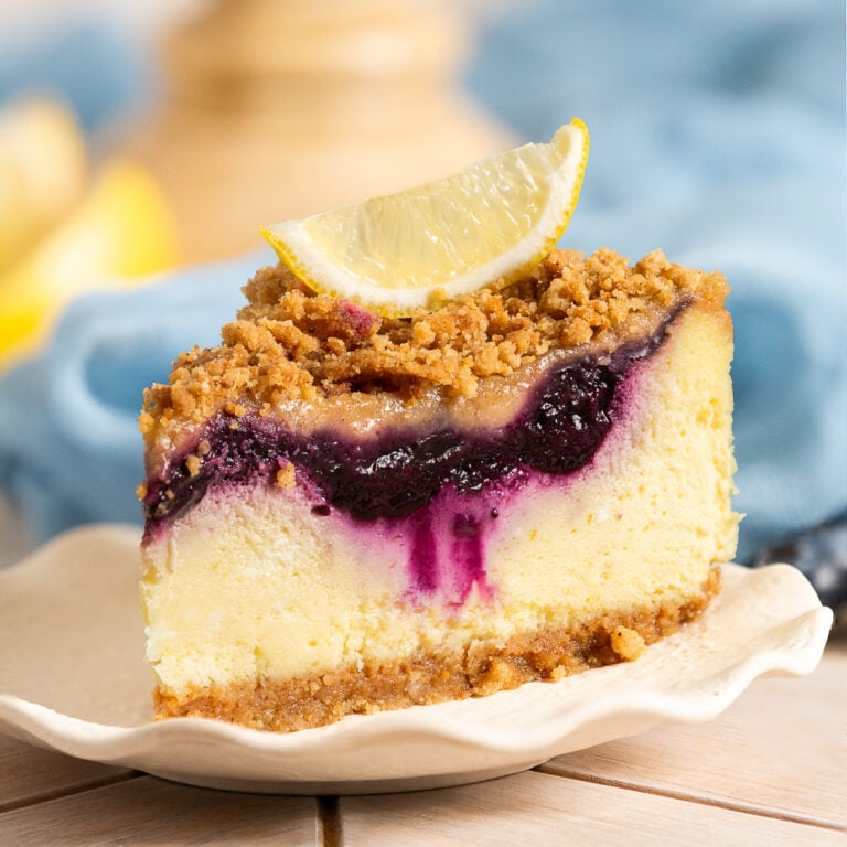 slice of blueberry lemon crumble cheesecake on a plate.