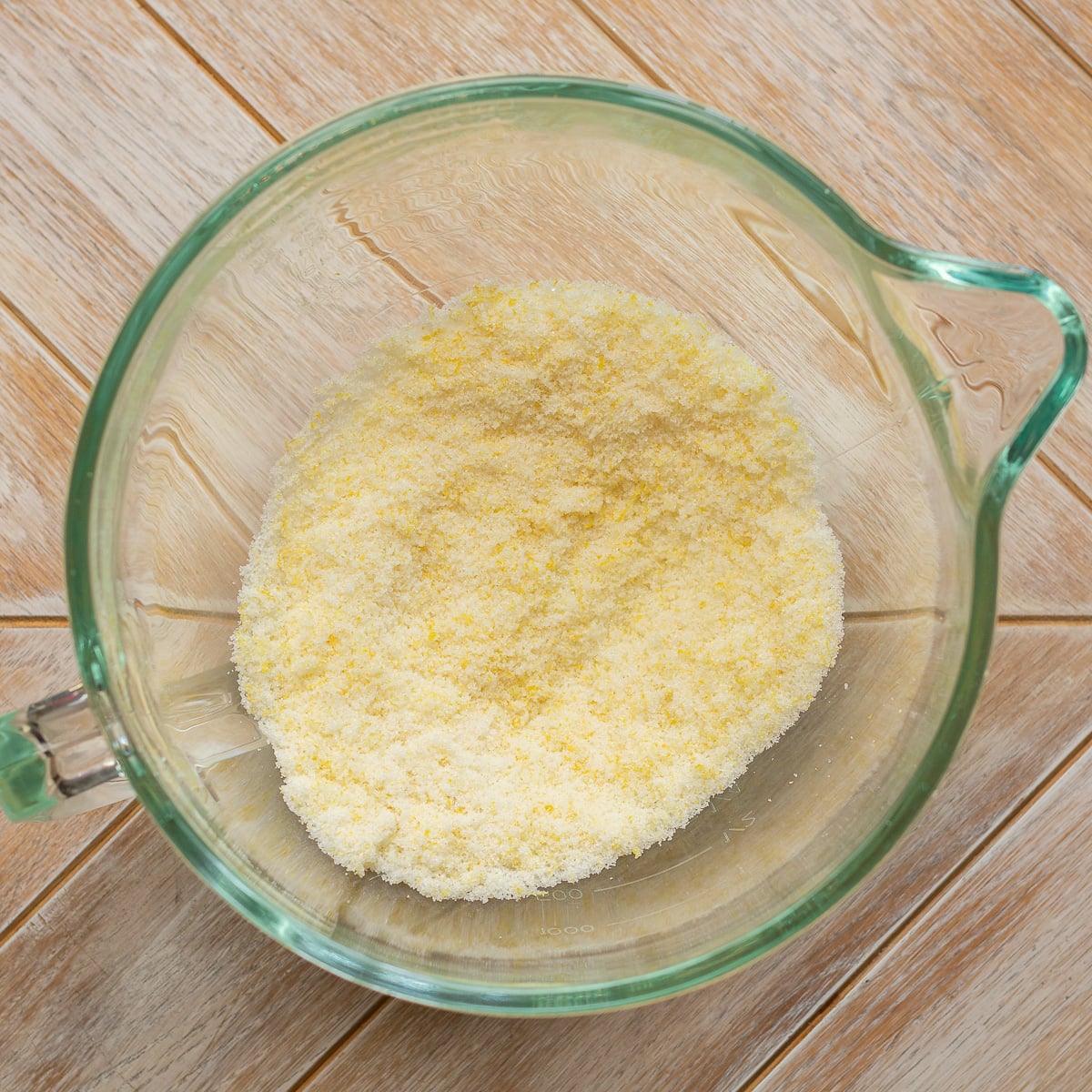 lemon zest rubbed into granulated sugar in a glass bowl.