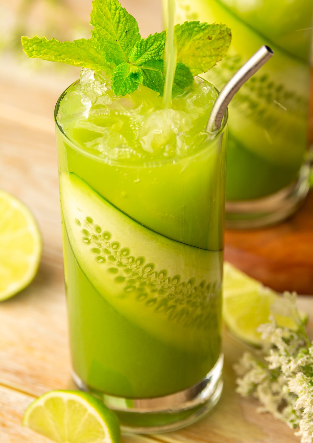 glass of cucumber limeade garnished with cucumber slice and mint.