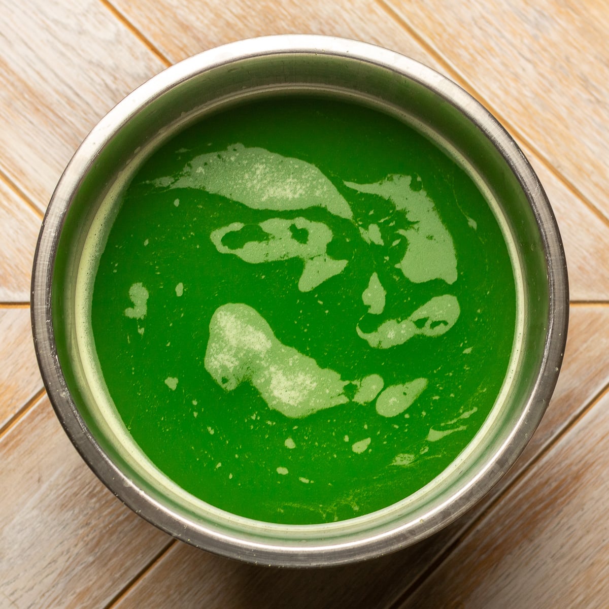 strained cucumber juice in a stainless steel bowl.