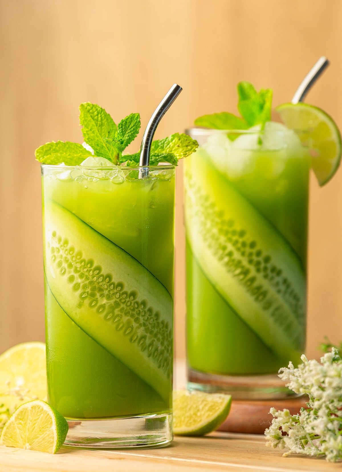 2 glasses of cucumber limeade garnished with cucumber slice and mint.