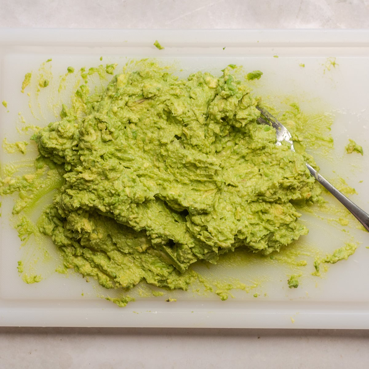 mashed avocados on a cutting board.