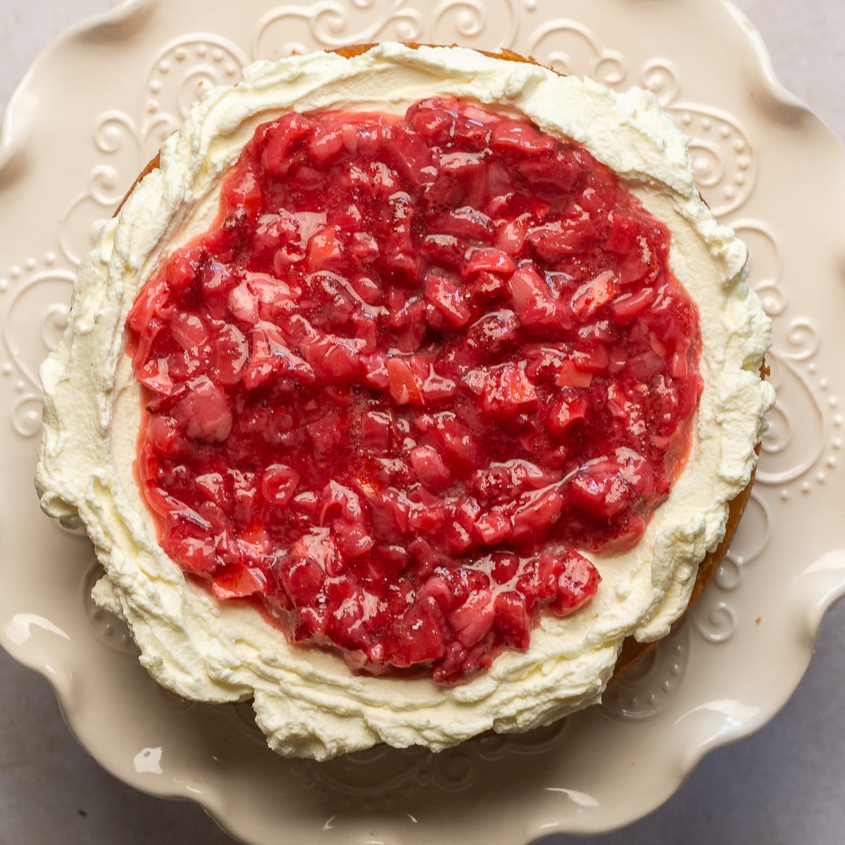 lychee cake layer topped with Chantilly frosting and strawberry-lychee filling.