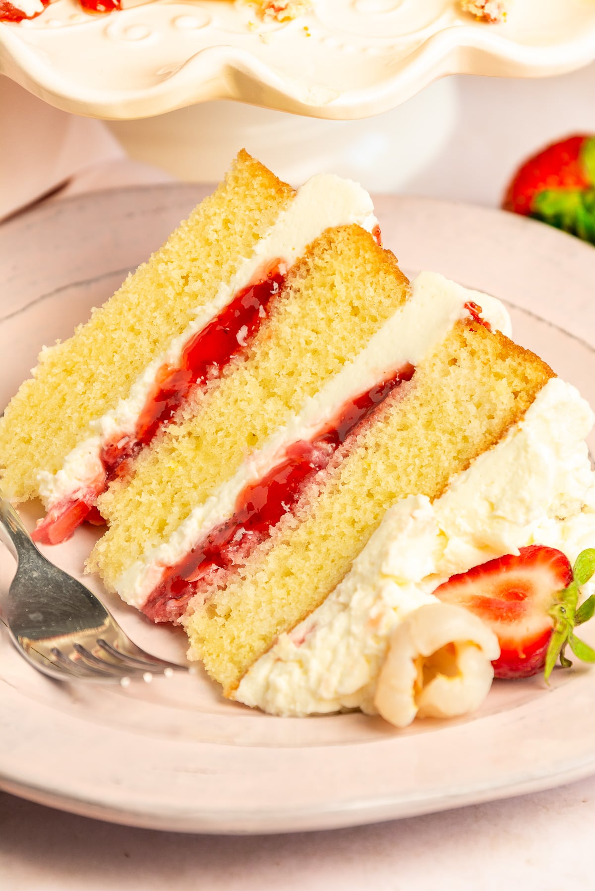 slice of lychee cake with Chantilly frosting and strawberry-lychee filling.