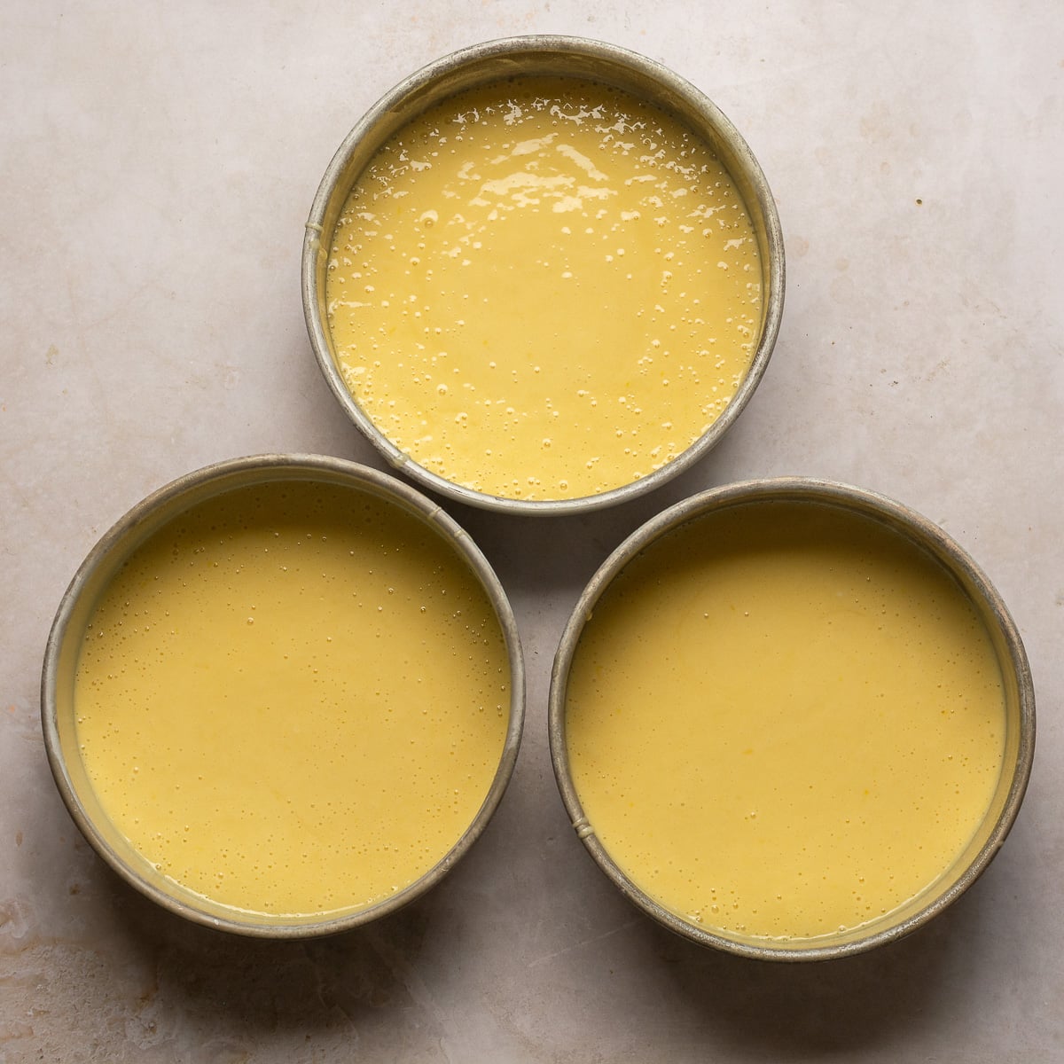 lychee cake batter in three baking pans.