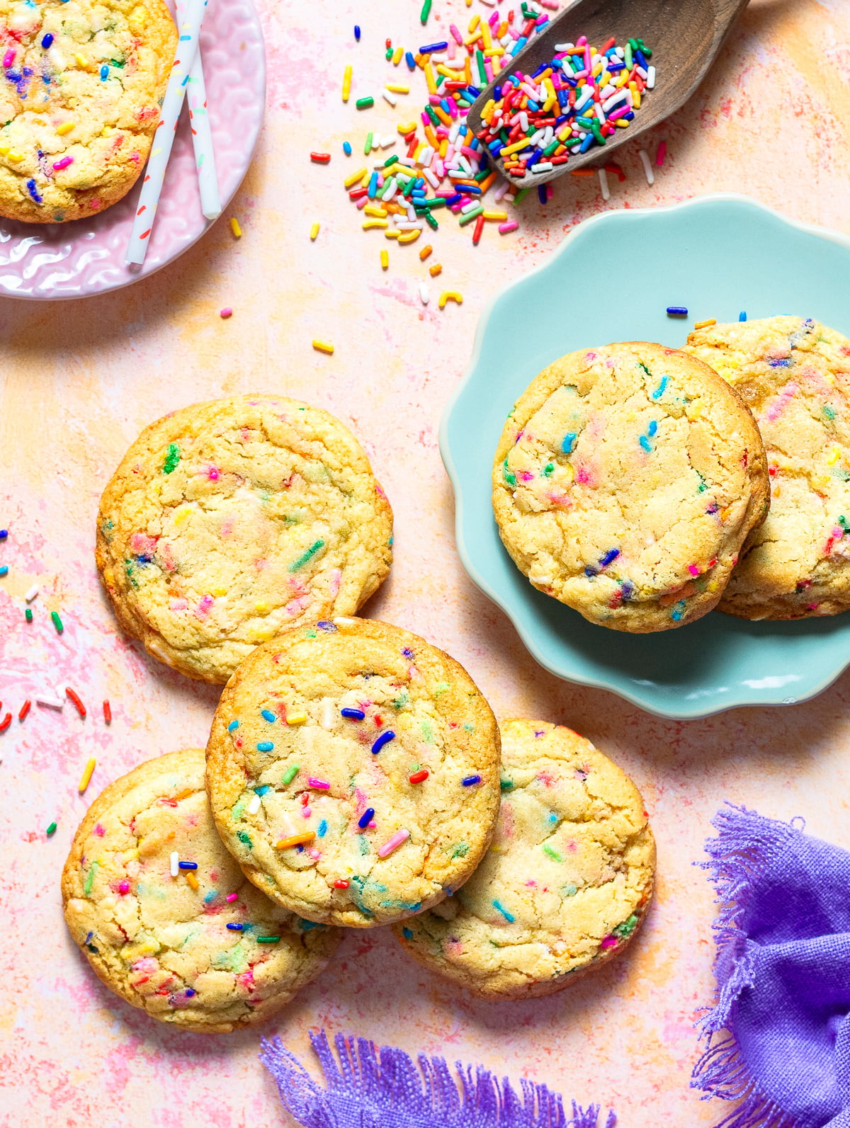 a pink countertop with confetti cookies scattered.