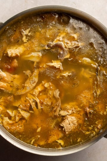 chicken stock from rotisserie chicken in a stainless steel stockpot.