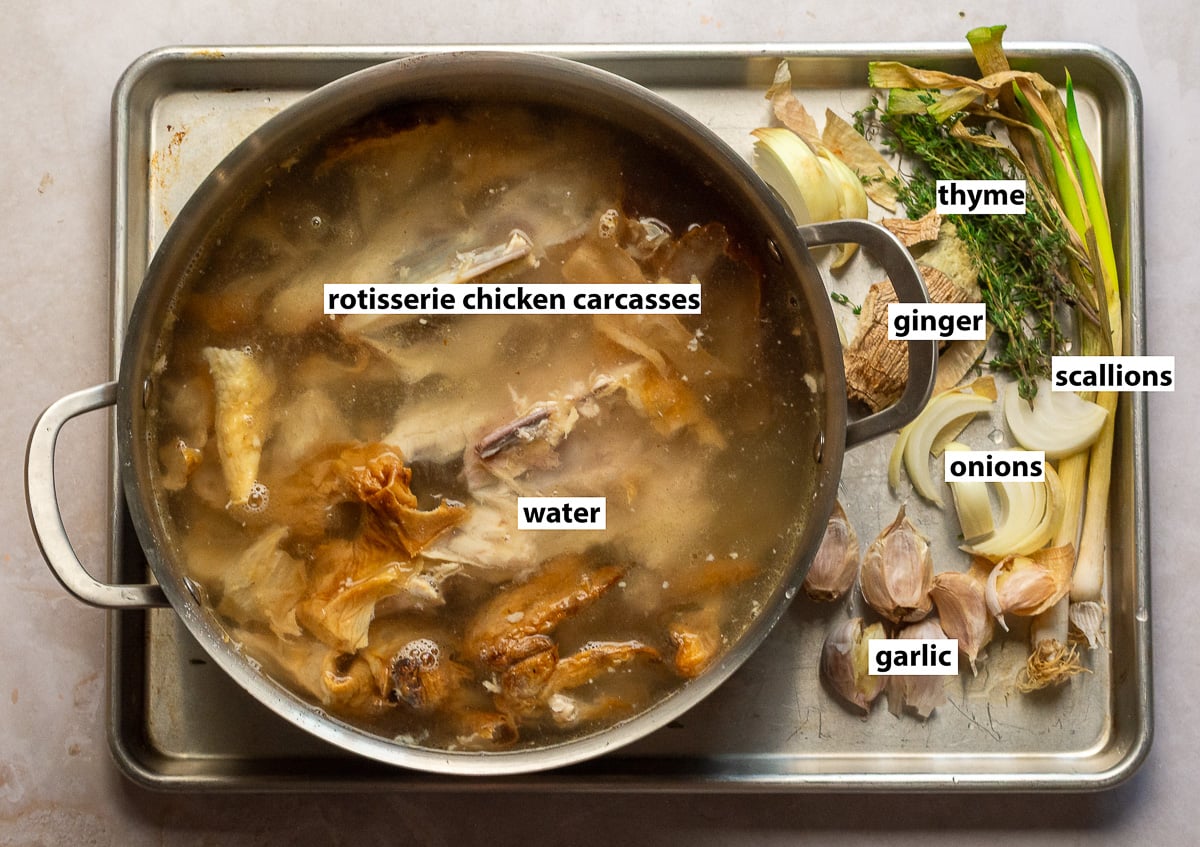 ingredients to make chicken stock from rotisserie chicken stock - rotisserie chicken carcasses, water, ginger, garlic, thyme, onions, scallions.