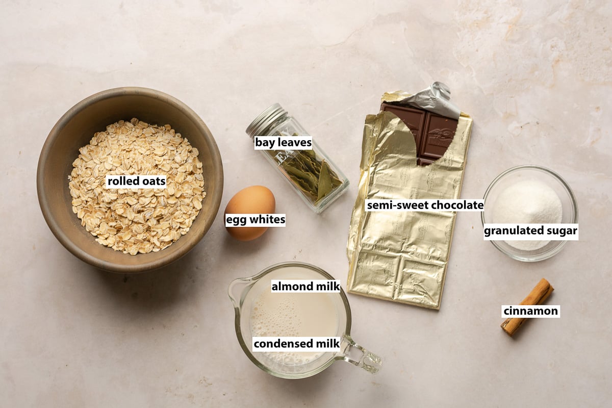 ingredients for smores oatmeal - rolled oats, egg whites, almond milk, sweetened condensed milk, almond milk, bay leaves, semi-sweet chocolate, granulated sugar and cinnamon.