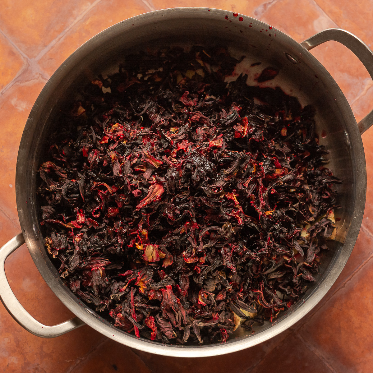 rinsed sorrel hibiscus in a stainless steel pot.